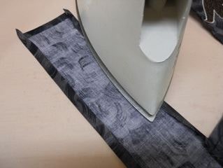 Pressing remaining folded tie edges.